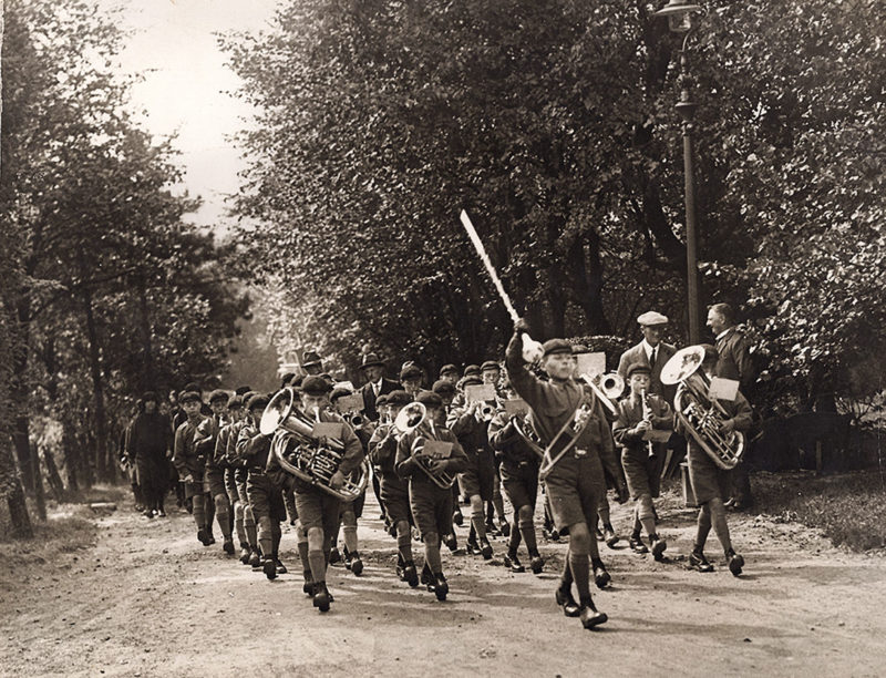 Boys band on summer camp, marching in the countryside