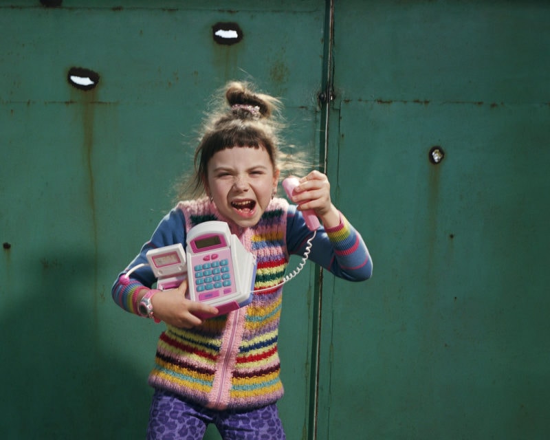 Kristina in Troyitske, Eastern Ukraine, an hour after the shelling. Sometimes she would pose with a toy telephone in front of her home’s green front gate which had been peppered with holes from flying shrapnel. Since the pictures were taken, Kristina has had to leave Luganke.